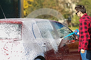 Manual car wash with pressurized water in car wash outside.Summe Washing. Cleaning Car Using High Pressure Water.