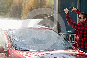 Manual car wash with pressurized water in car wash outside.Summe Washing. Cleaning Car Using High Pressure Water.