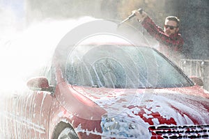 Manual car wash with pressurized water in car wash outside.Summe Washing. Cleaning Car Using High Pressure Water.