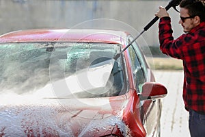 Manual car wash with pressurized water in car wash outside.Summe Washing. Cleaning Car Using High Pressure Water.