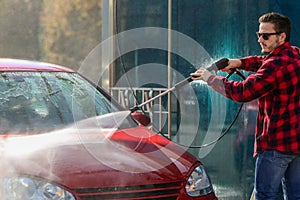 Manual car wash with pressurized water in car wash outside.Summe Washing. Cleaning Car Using High Pressure Water.