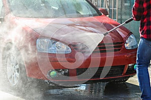 Manual car wash with pressurized water in car wash outside.Summe Washing. Cleaning Car Using High Pressure Water.