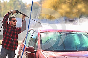 Manual car wash with pressurized water in car wash outside.Summe Washing. Cleaning Car Using High Pressure Water.