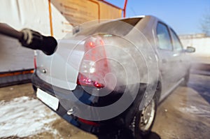 Manual car wash with pressurized water in car wash outside. Concept of summer car washing and cleaning car using high photo