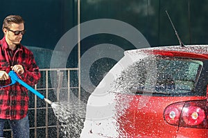 Manual car wash with pressurized water in car wash outside.Summe Washing. Cleaning Car Using High Pressure Water.