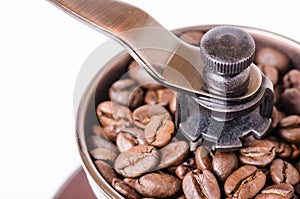 Manual coffee grinder with coffee beans. Isolated. White background. Modern style. Roasted coffee beans.