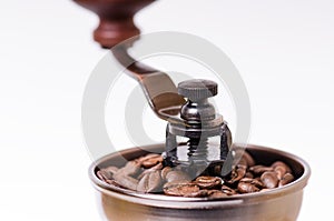 Manual coffee grinder with coffee beans. Isolated. White background. Modern style. Roasted coffee beans.