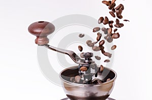 Manual coffee grinder with coffee beans. Isolated. White background. Modern style. Roasted coffee beans. Levitation coffee beans