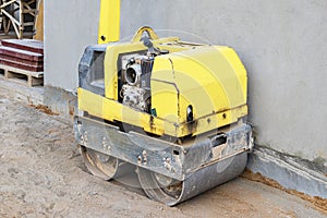 Manual compact asphalt roller for tamping soil at a construction site