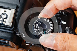 Manual dial mode on dslr camera with fingers on the dial