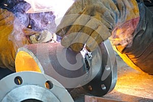 Manual electric arc welding of the junction Du 100 and flange