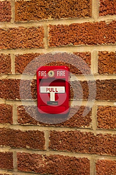 Manual fire alarm activation pull station on masonry wall