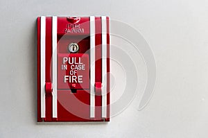 Manual fire alarm red box pull on the white concrete wall