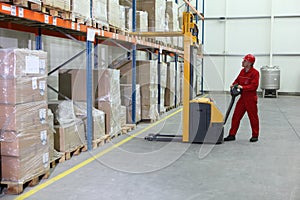 Manual forklift operator at work in warehouse