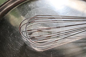 Manual hand mixer for blending, beating, Egg beater  on metal background. Metal stainless steel kitcenware utensil
