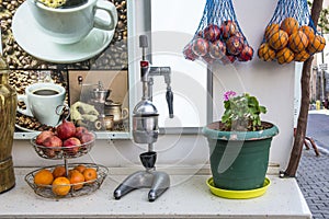 Manual juicer with granate apples and oranges.