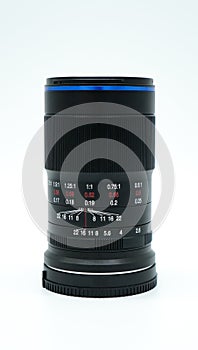 Manual macro photography lens standing upright in front of white background