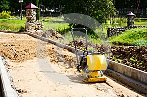 A manual paver evens out the top layer of sand