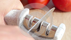 Manual sharpening of a knife in a special sharpener