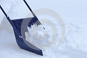 Manual snow removal with snow scoop after blizzard