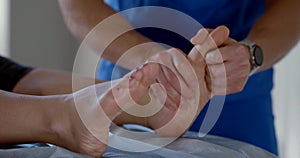 Manual therapist is massaging feet of female patient in osteopathic clinic, curing of diseases photo