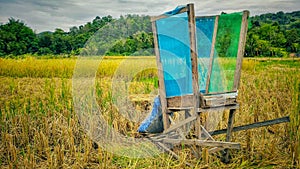 manual thresher as equipment made of wood and fiberglass wire mesh to remove rice seeds from stalk