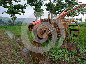 A manual tractor made of steel for plowing rice fields used to prepare land for rice cultivation.