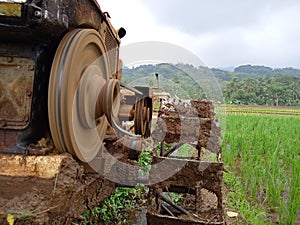 A manual tractor made of steel for plowing rice fields used to prepare land for rice cultivation.
