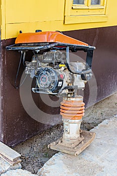 Manual vibratory rammer at the construction site prepared for excavation work to compact the earth`s surface