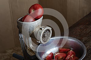 Manual vintage meat grinder and ripe tomatoes on the table