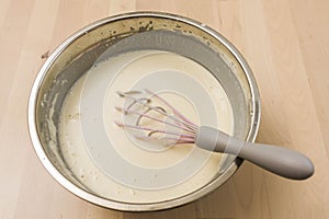 Manual whisk mixing cream and egg for cooking dessert