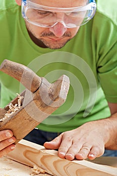 Manual woodwork - man with planer and slat