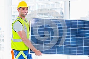 Manual worker carrying solar panel at office