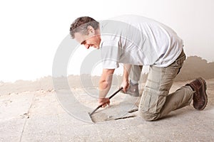 Manual worker disassembling old floor tiles