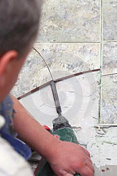 Manual worker disassembling old floor tiles