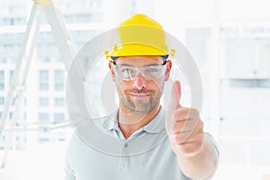 Manual worker gesturing thumbs up at site