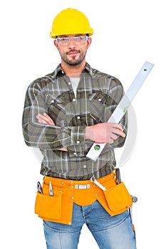 Manual worker holding spirit level with arms crossed