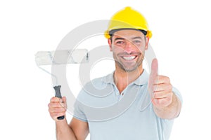 Manual worker with paint roller gesturing thumbs up