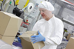 Manual worker at production line dealing with boxe