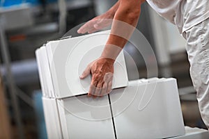 Manual worker at production line dealing with boxes