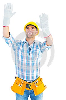 Manual worker raising hands while looking up