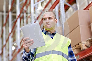 Manual worker with tablet pc at warehouse