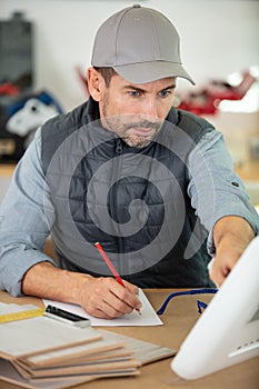 manual worker using computer in workshop