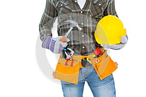 Manual worker wearing tool belt while holding hammer and helmet