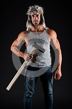 Manual worker. Worker hold hammer in strong arms. Athletic man black background. Construction and building. Physical