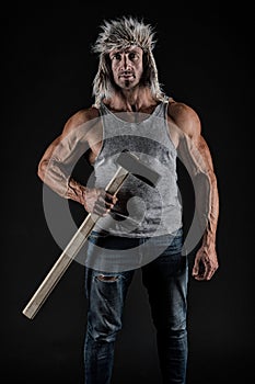 Manual worker. Worker hold hammer in strong arms. Athletic man black background. Construction and building. Physical