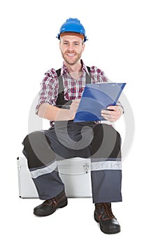 Manual worker writing on clipboard over white background
