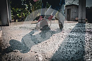 Manually pouring concrete for a surface adjustment on a construction site