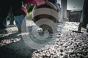 Manually pouring concrete for a surface adjustment on a construction site