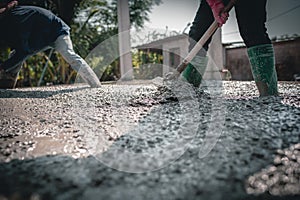 Manually pouring concrete for a surface adjustment on a construction site